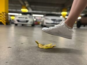 Close-up of a foot about to step on a banana peel in an underground parking lot.